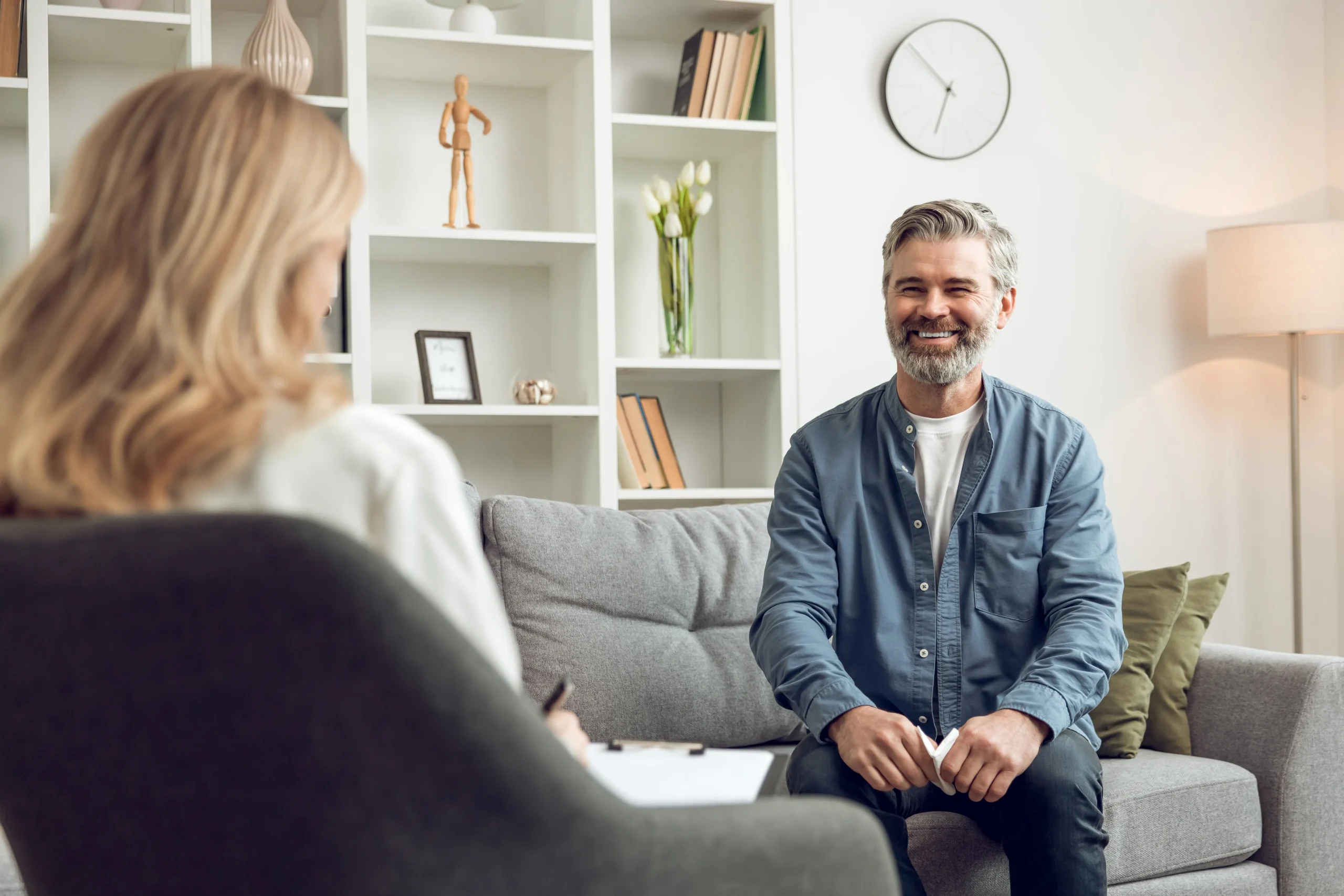 Middle-aged man speaking comfortably with a psychologist during an individual therapy session, highlighting supportive mental health treatment.